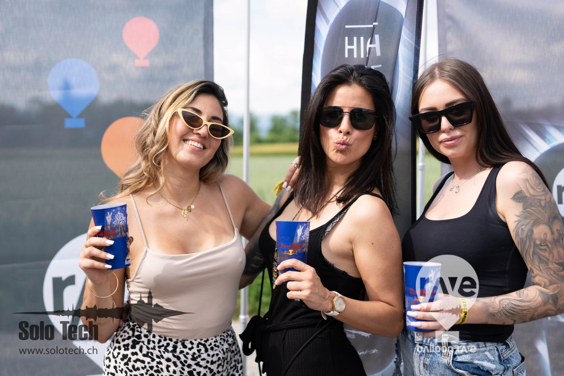 Gäste mit Drinks vor dem Balloon Rave Backdrop