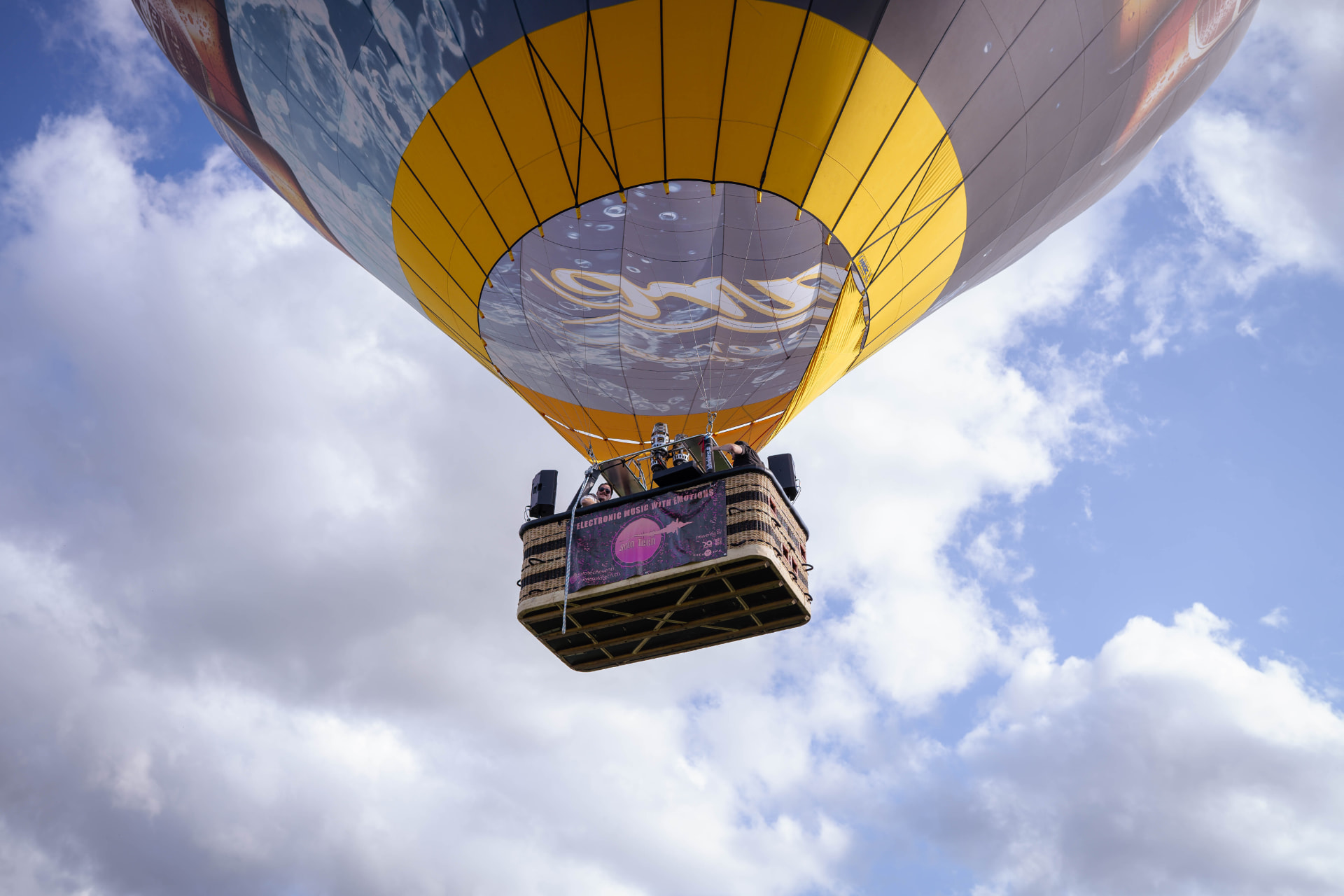 Blick von unten auf den Ballon mit Gästen im Korb