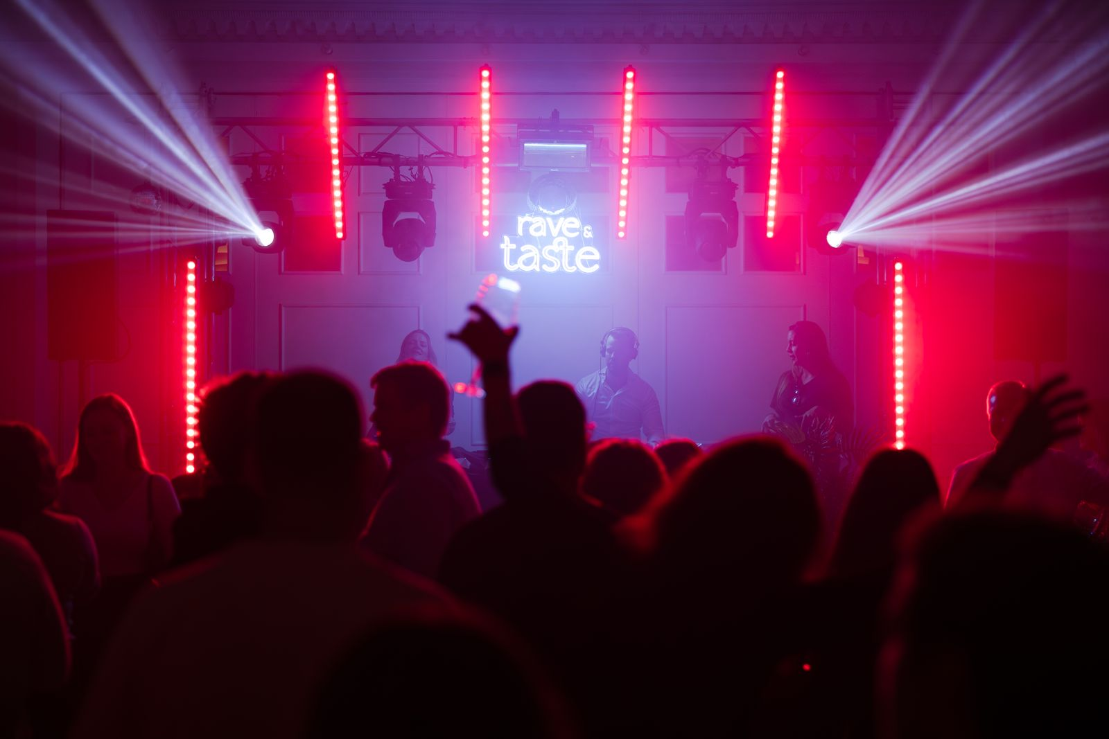 Gäste feiern vor der Rave & Taste Bühne mit rotem Licht