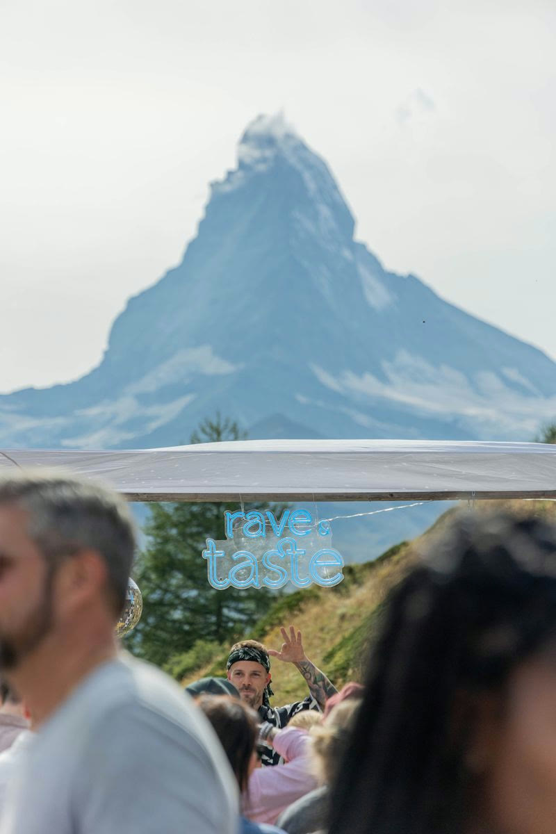 Rave & Taste Leuchtschild mit DJ und Gästen vor dem Matterhorn in Zermatt