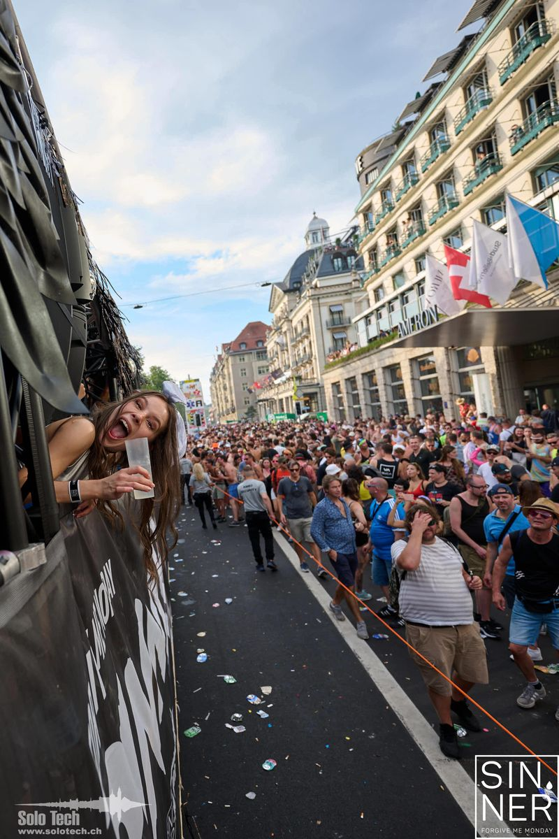 Lachender Gast am Love Mobile mit der Street-Parade-Menge im Hintergrund