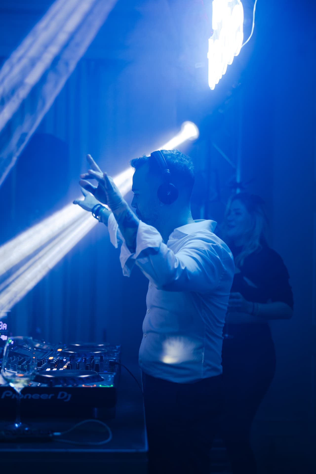 DJ am Mischpult im blauen Licht eines Rave & Taste Events